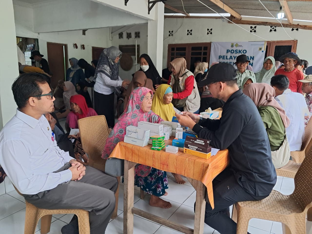 Pihak RSUD Karawang sedang memberikan obat kepada warga yang terdampak banjir